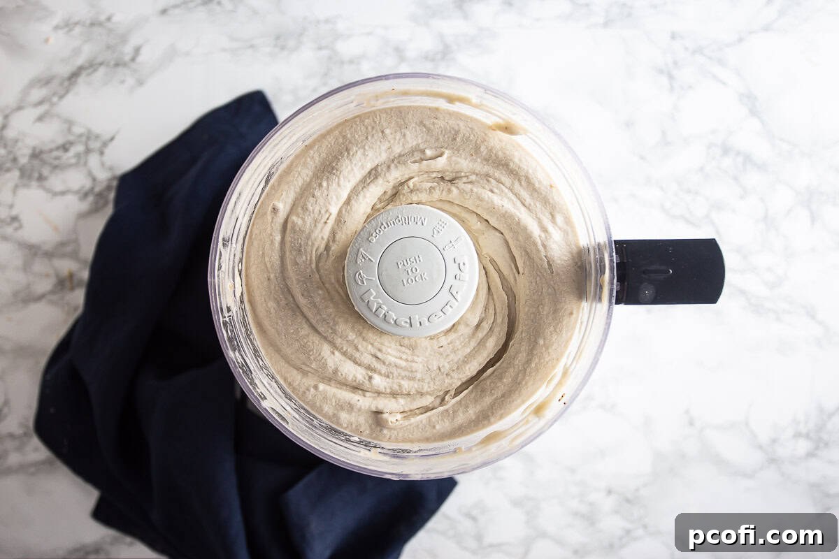 Pureed frozen bananas in a food processor showing the smooth consistency. 