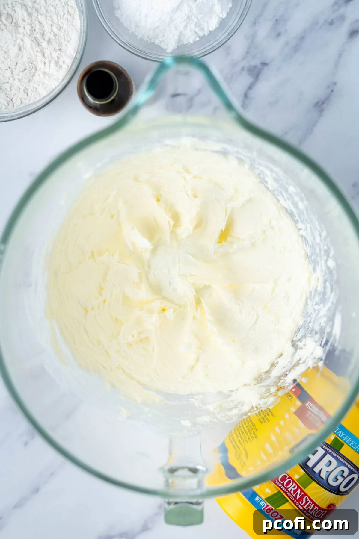 Creamed butter and salt in a mixing bowl, light and fluffy, ready for the next step of the cookie recipe.