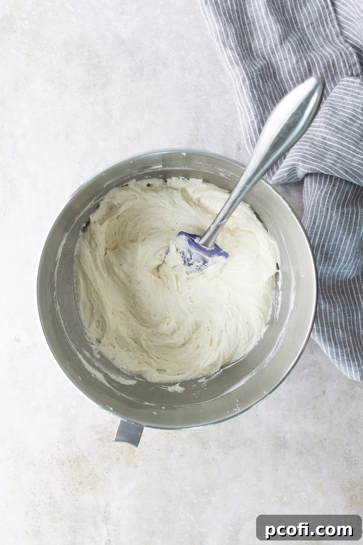 Creamy cream cheese frosting for zucchini cake being prepared in a stand mixer.