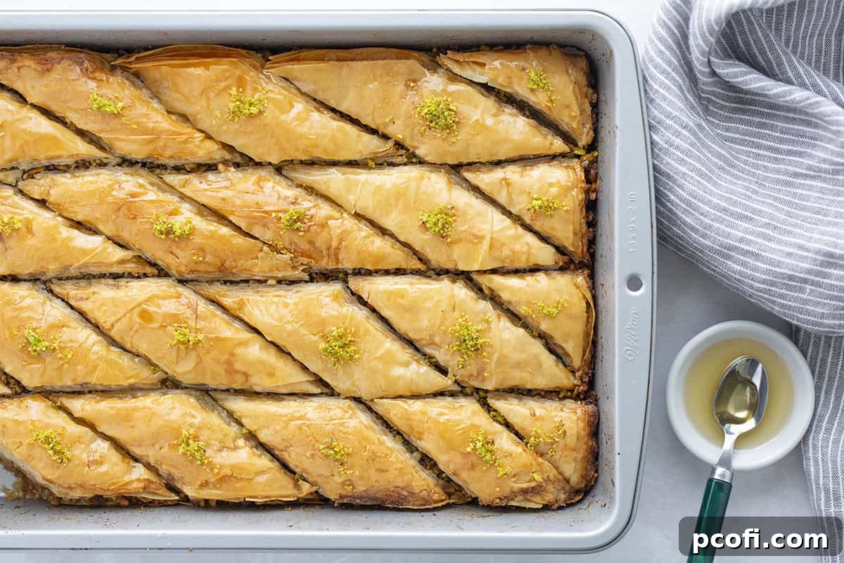 A freshly baked tray of Baklava, glistening with honey syrup and cut into perfect diamond shapes, ready to be served.