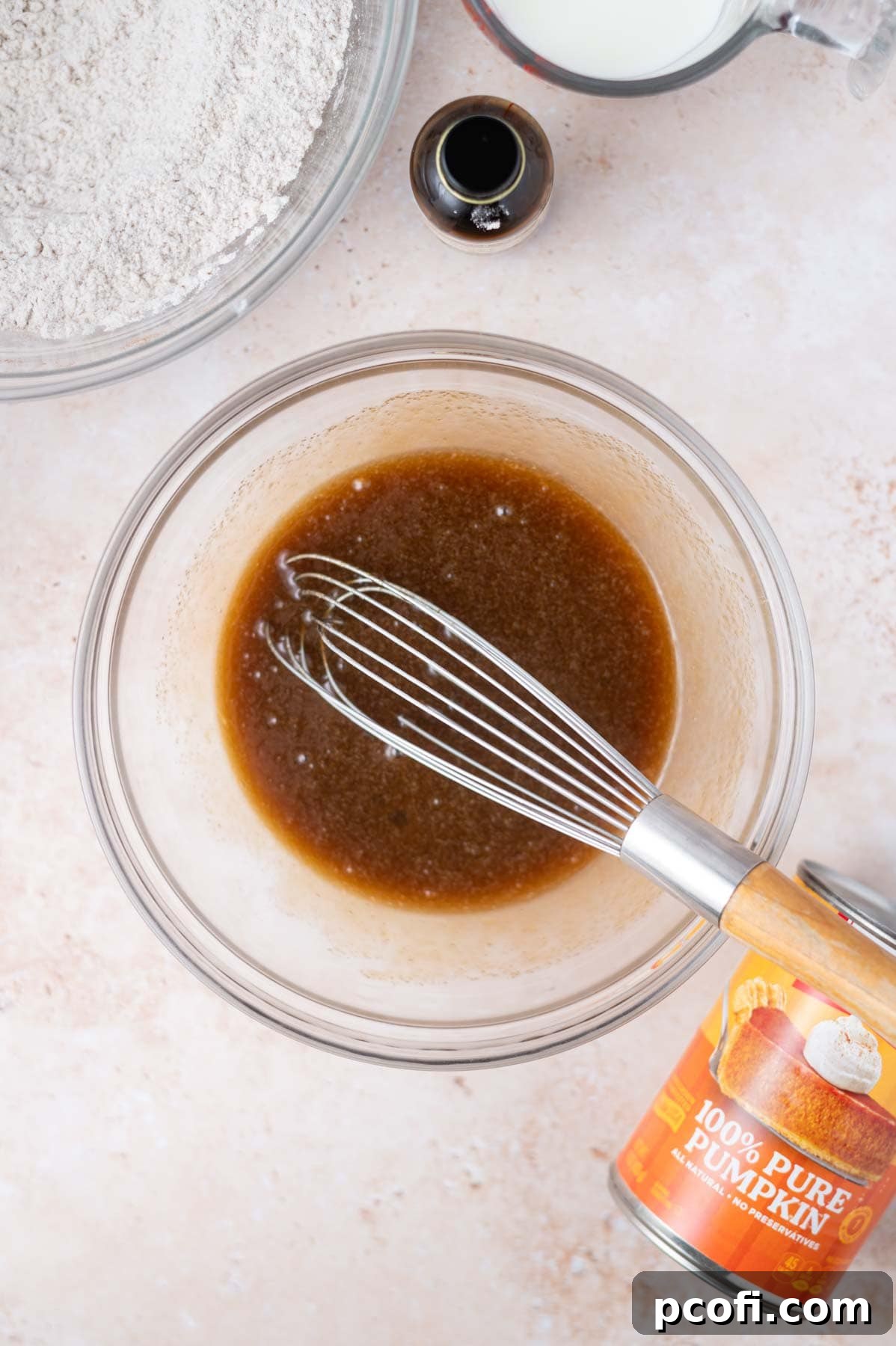 Melted butter, brown sugar, and a large egg are whisked together in a medium bowl, creating a smooth mixture.