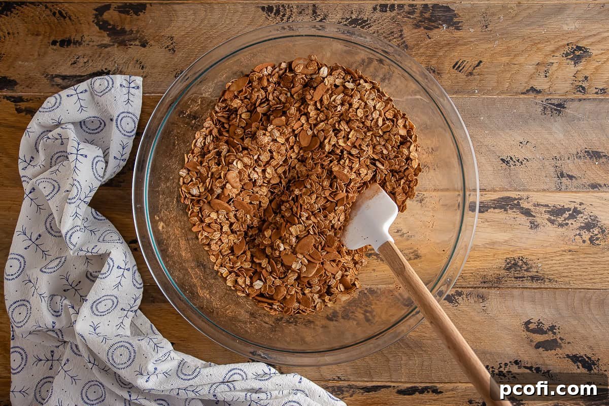 Dry ingredients for chocolate granola in a large glass bowl after being mixed together, showing an even distribution.