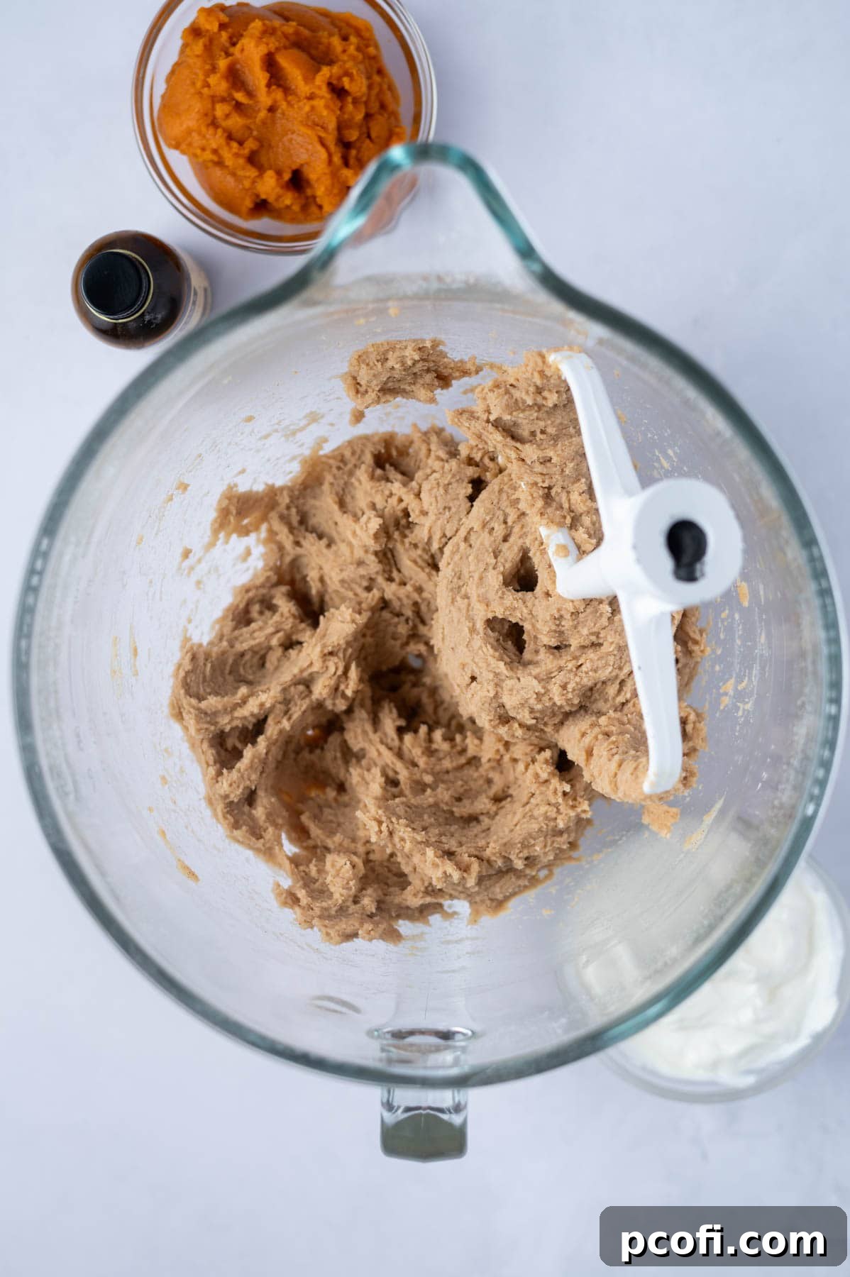 The cake batter in a mixing bowl after the eggs have been incorporated, appearing smoother and more cohesive than in the previous step.