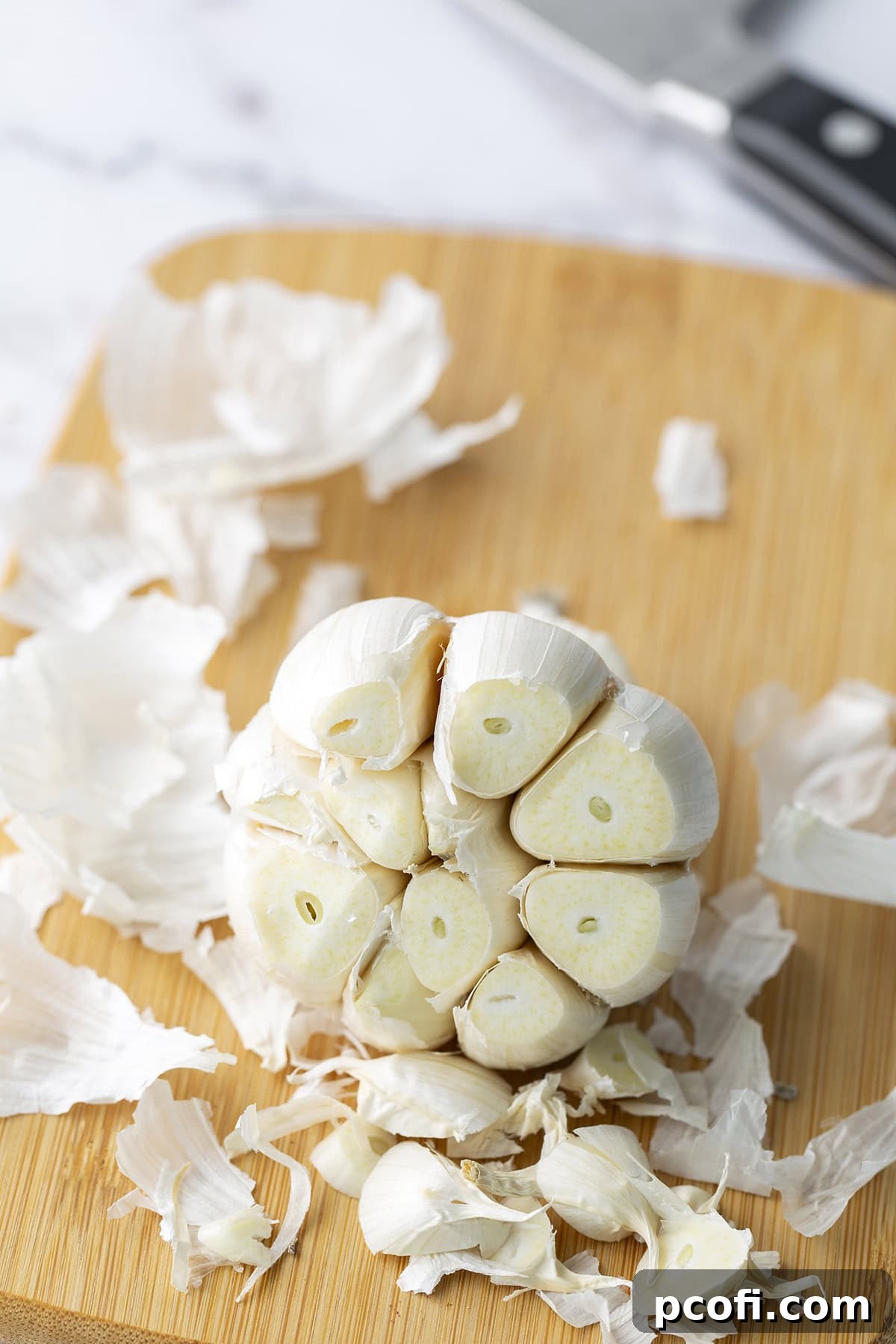 Tip of garlic sliced off, revealing the white ends of the cloves.