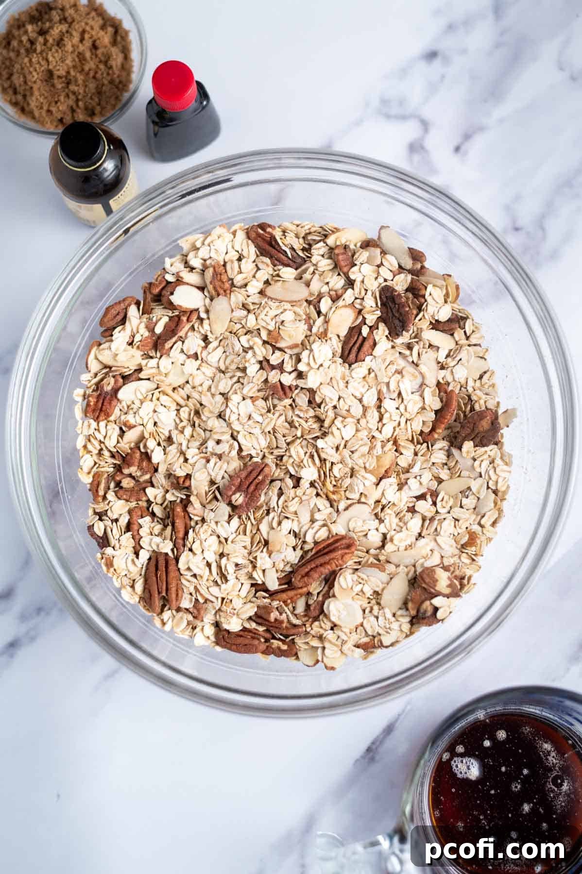 Dry ingredients: rolled oats, pecans, sliced almonds, and salt mixed together in a large mixing bowl.