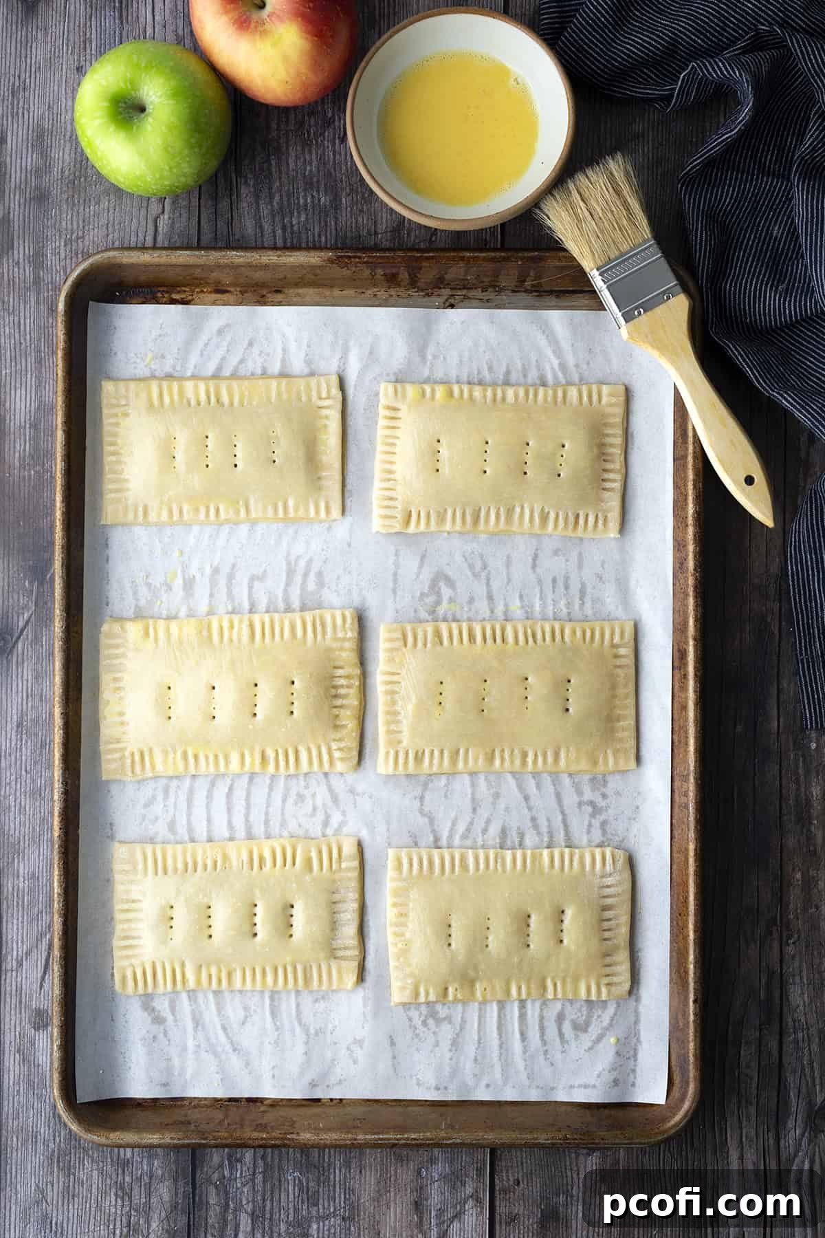 Unbaked pop tarts with crimped edges and egg wash