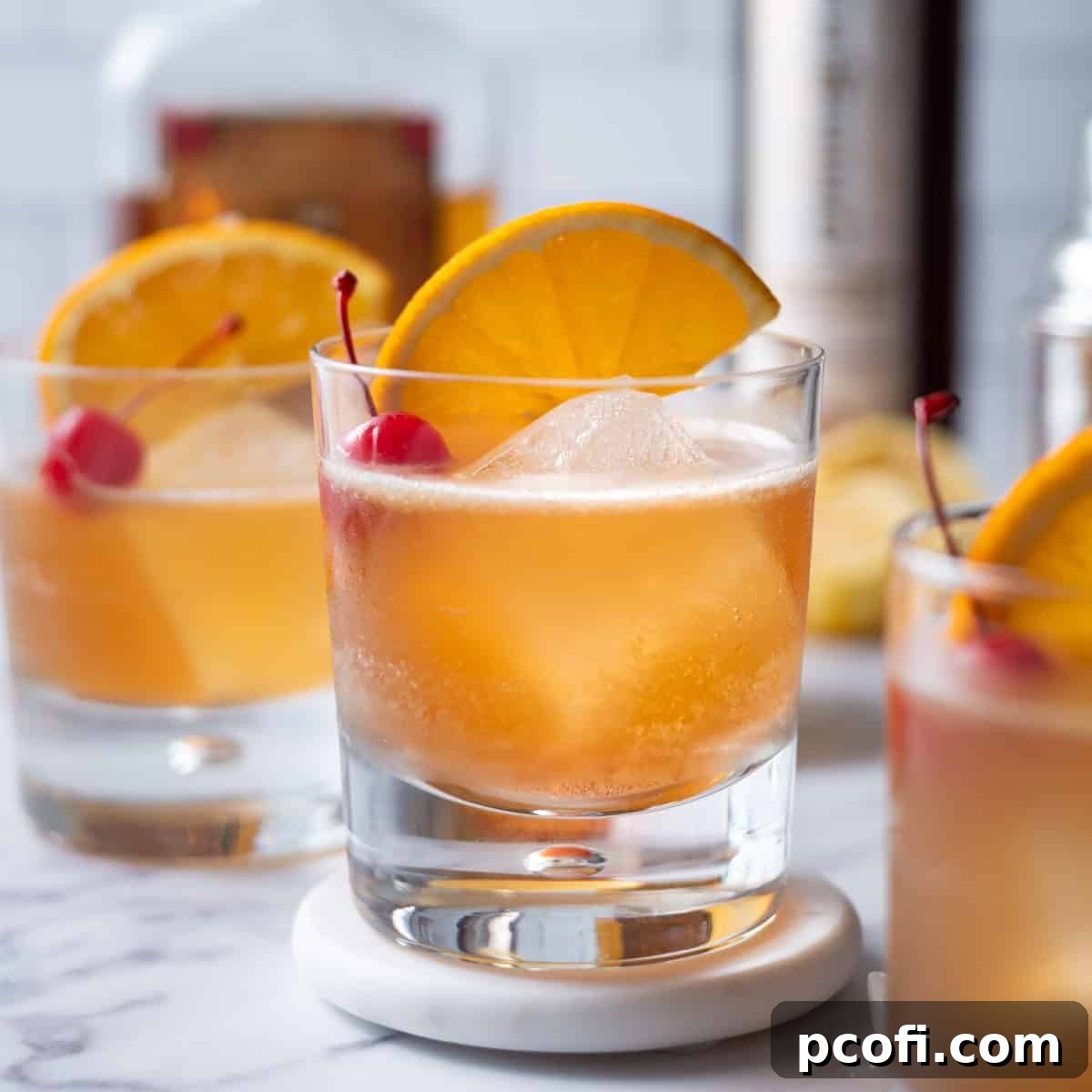 Classic Amaretto Sour cocktail garnished with an orange slice and cherry, served on a stylish coaster