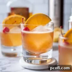 Amaretto Sour cocktail garnished with an orange slice and cherry, served on a stylish coaster