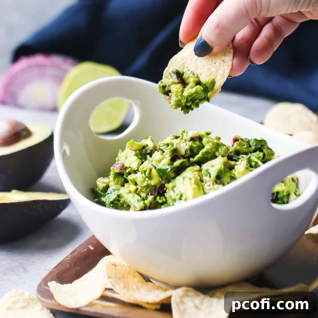 Dipping a corn chip into a bowl of simple guacamole.