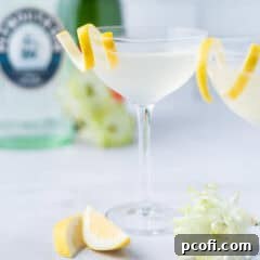 French 75 cocktails in coupe glasses with gin and champagne bottles in the background, ready for serving.