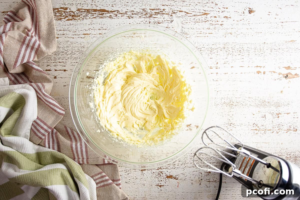 The pear tart filling mixture after the eggs have been fully beaten in, appearing smooth and pale.