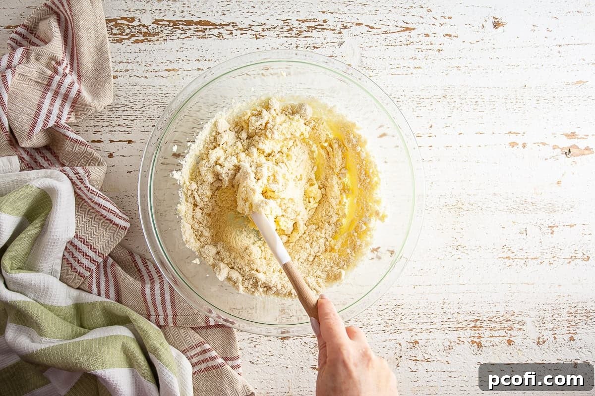 Almond meal being carefully folded into the wet ingredients for the tart filling.