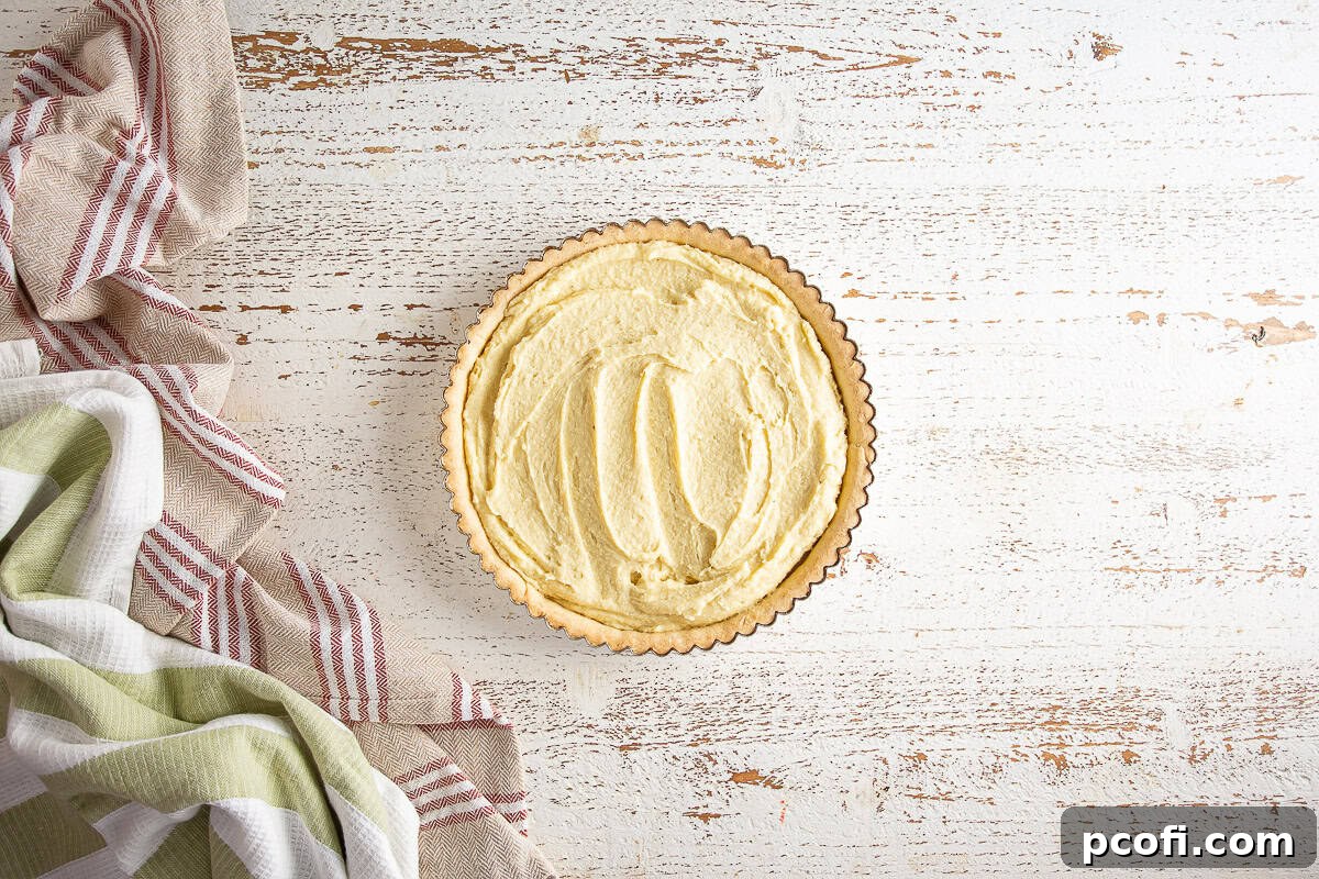 Pear tart filling evenly spread into the pre-baked tart shell.