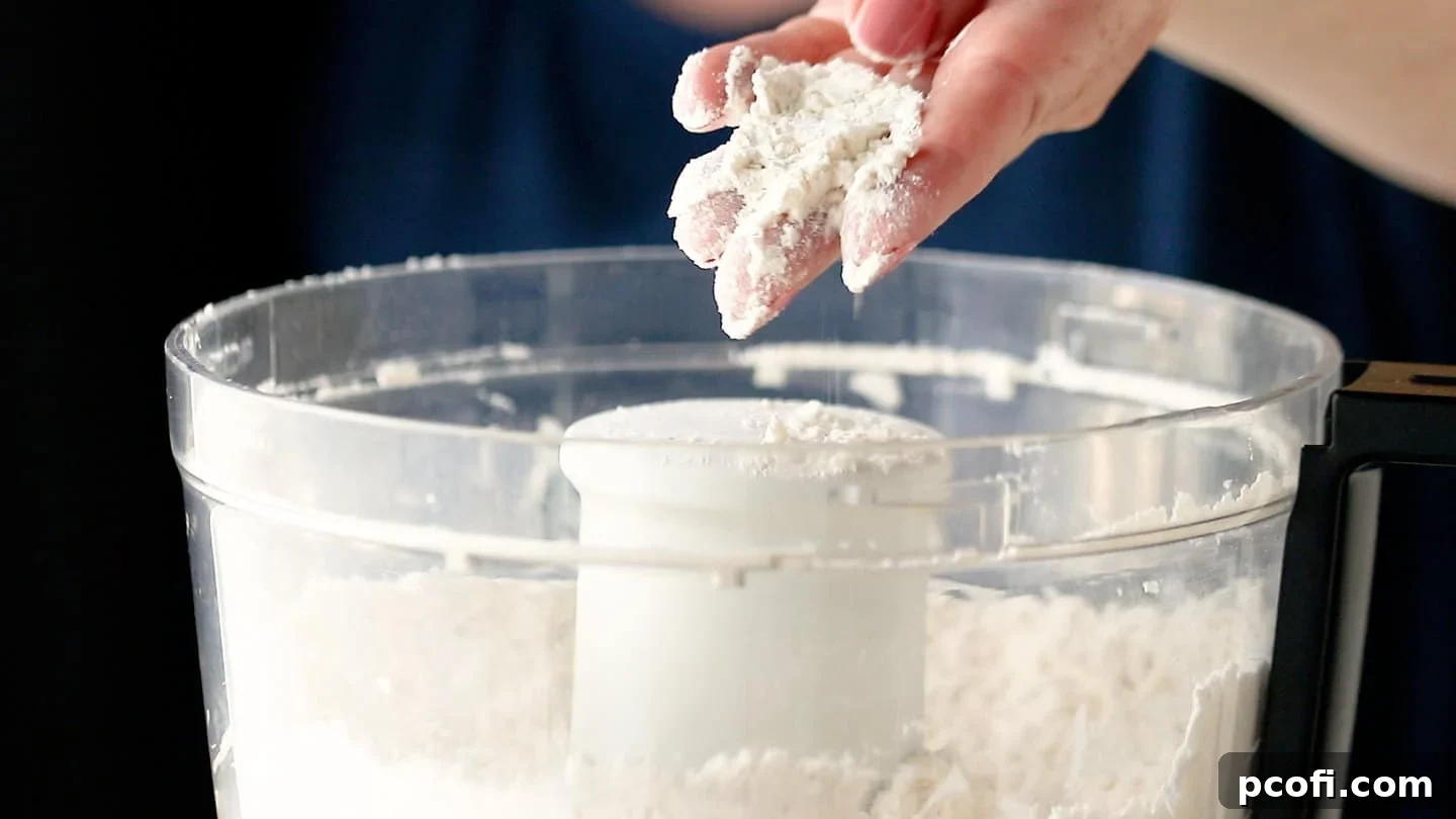 Butter pieces cut into the dry ingredients for tart dough, resulting in a coarse, crumbly mixture.