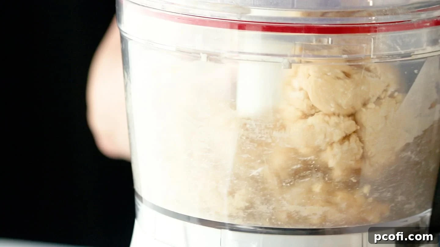 Tart dough has formed a cohesive ball in the food processor bowl.