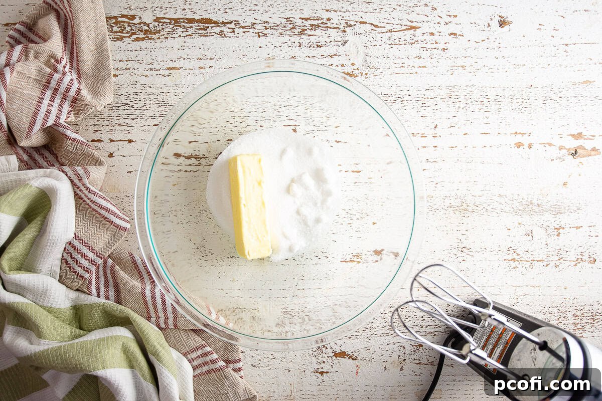 Sugar, softened butter, and salt in a glass mixing bowl before creaming for the frangipane filling.