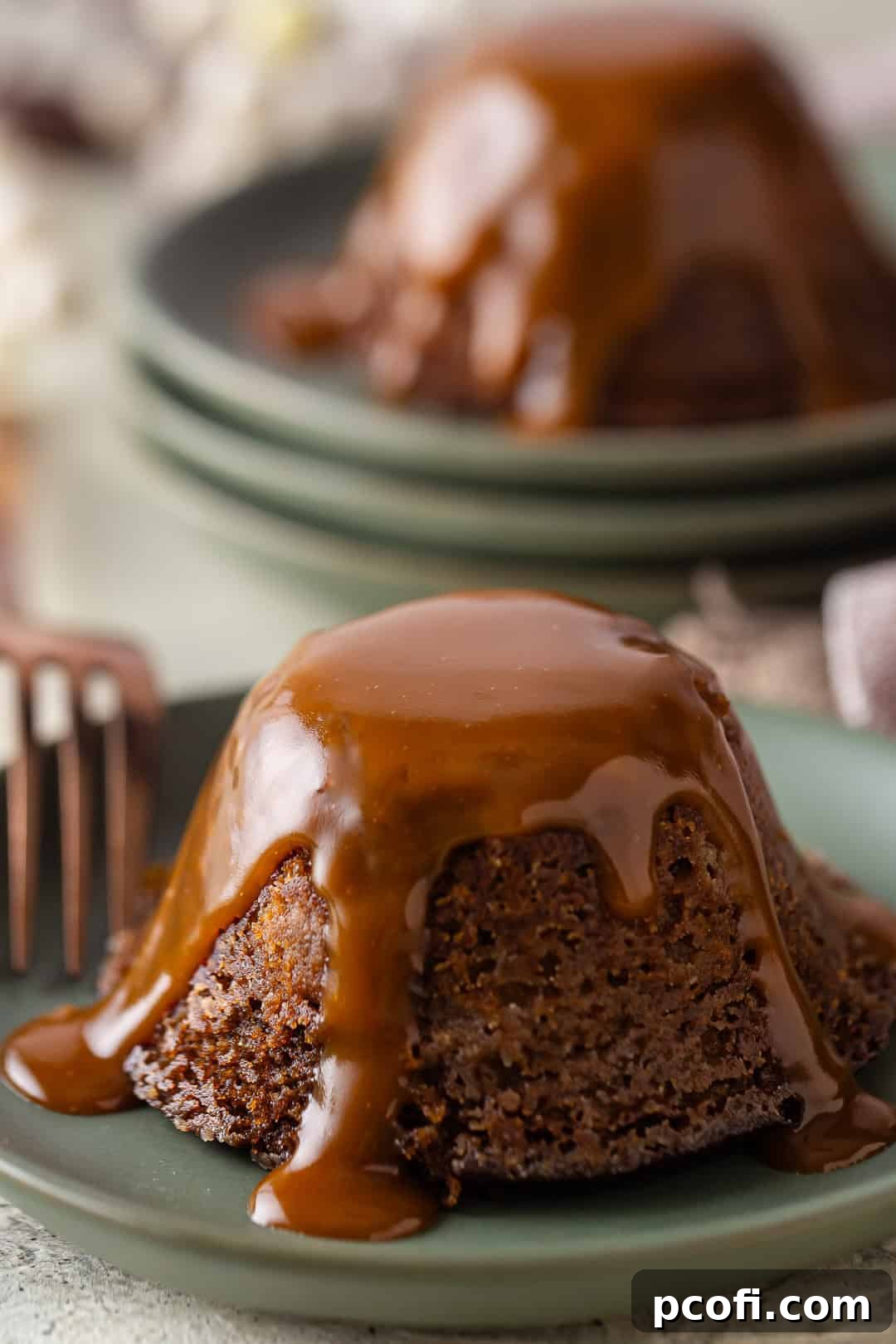 A perfectly baked sticky toffee pudding with rich toffee sauce generously poured over the top, ready for serving.