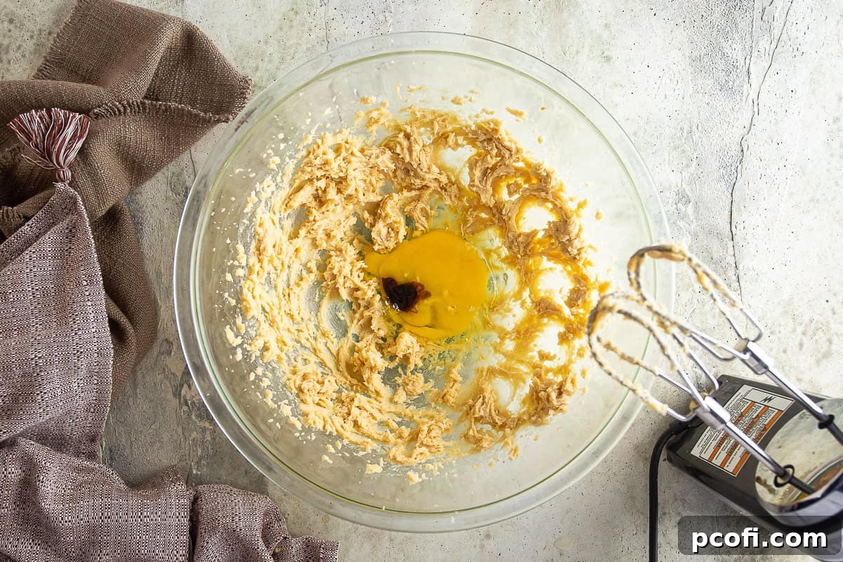 Creamed butter and brown sugar mixture with egg and vanilla extract added, ready for the next steps.