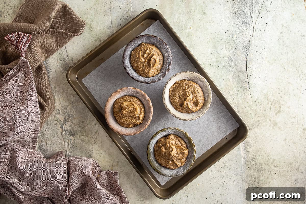 Sticky toffee pudding batter divided into individual ramekins, ready for baking.