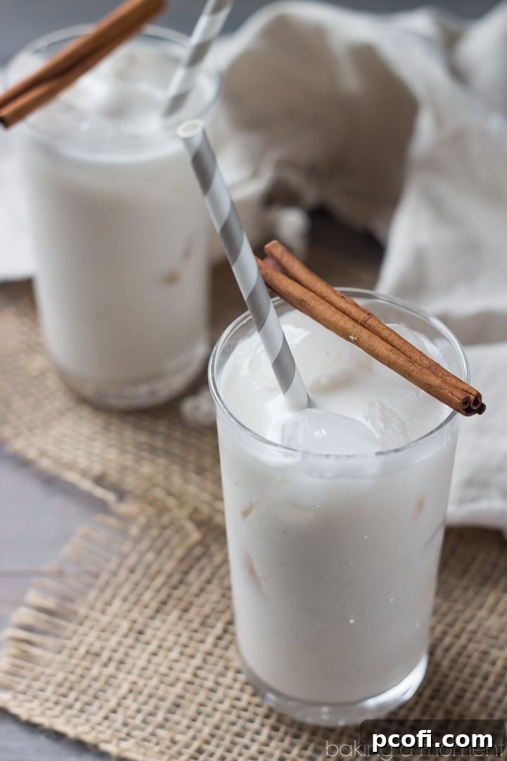 Three glasses of Coconut Horchata on a wooden surface, garnished with cinnamon sticks, ready for a tropical refreshment