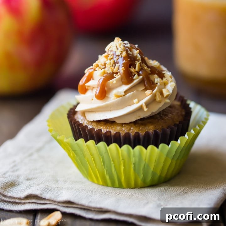 Caramel Apple Cupcakes: moist, subtly spiced apple cake topped with salted caramel buttercream, drizzled with caramel sauce and garnished with chopped peanuts.