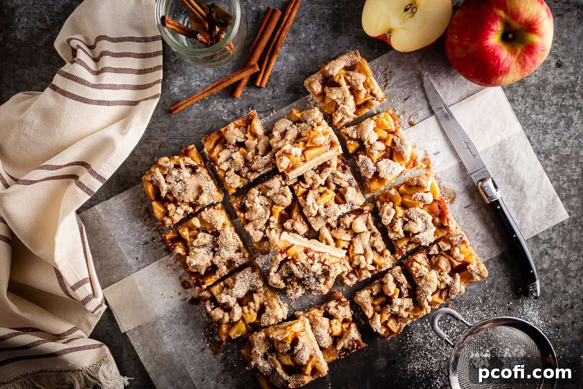 Delicious apple pie bars, perfectly cooled and neatly sliced into squares, ready to be enjoyed as a delightful dessert.