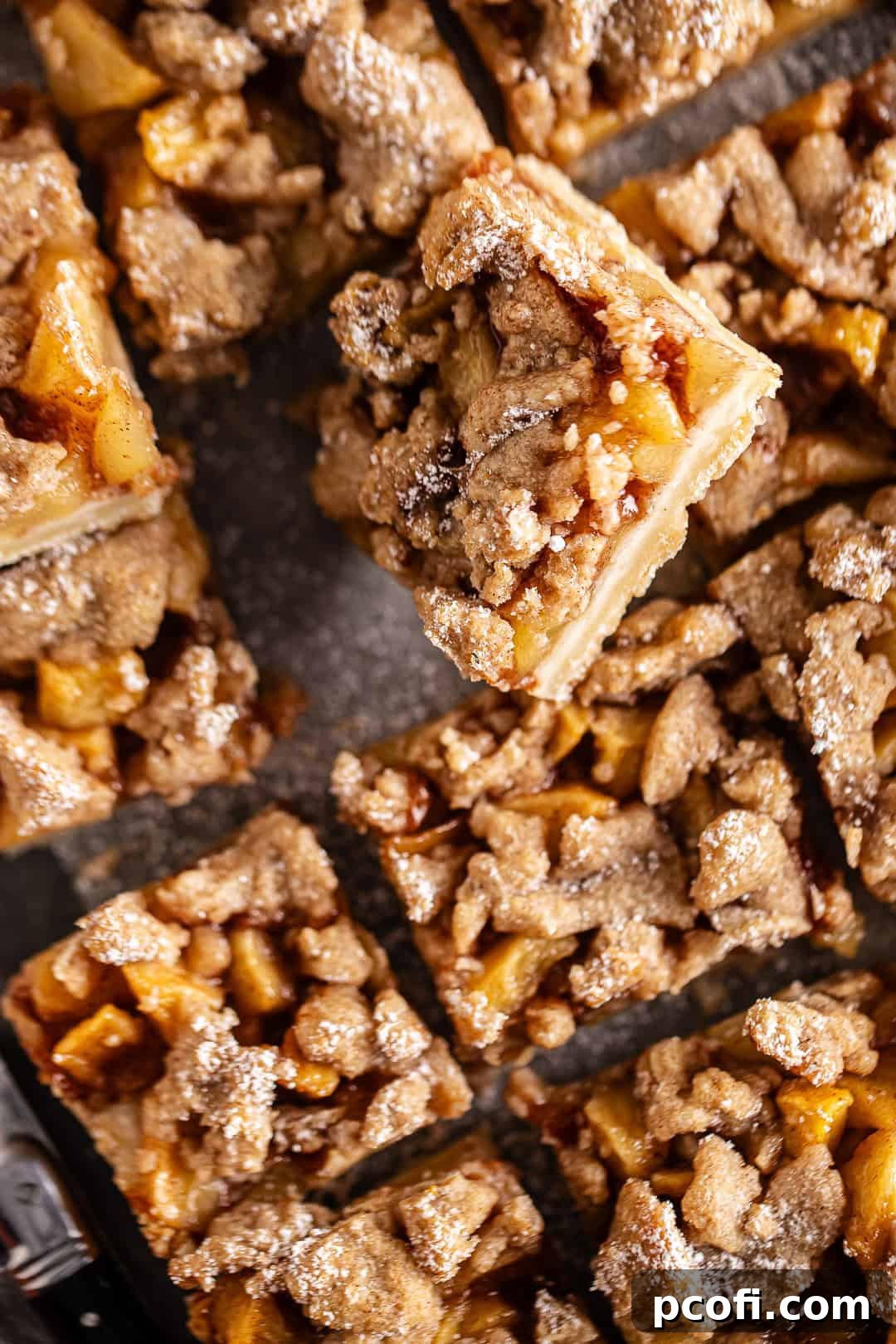 Beautifully cut apple pie bars arranged enticingly on a wooden board, showcasing their layers and inviting texture.