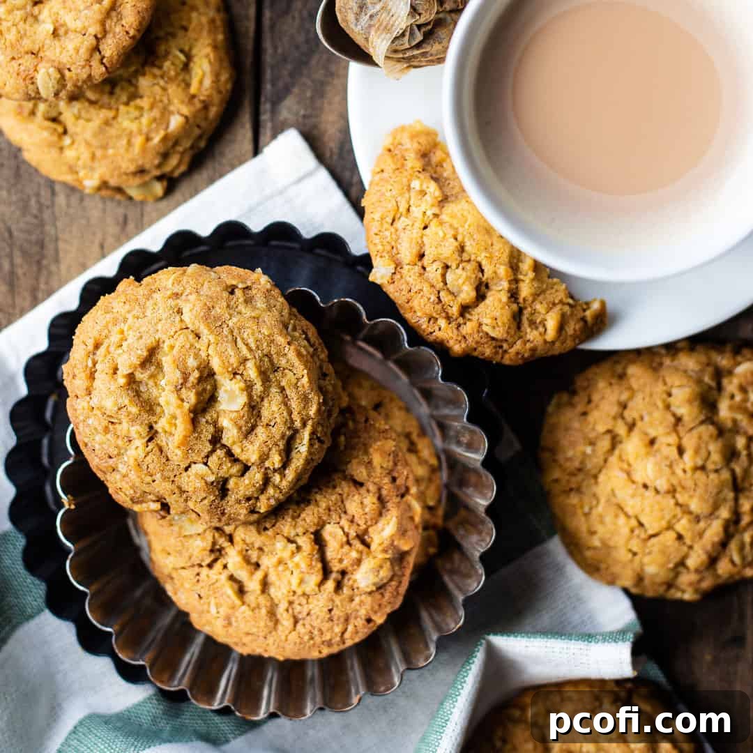 Crisp and buttery Irish Oat Cookies displayed in a decorative fluted pan, accompanied by a steaming cup of tea.