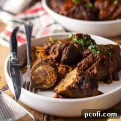 Close-up of a single Braciole roll, perfectly cooked and glistening with sauce.