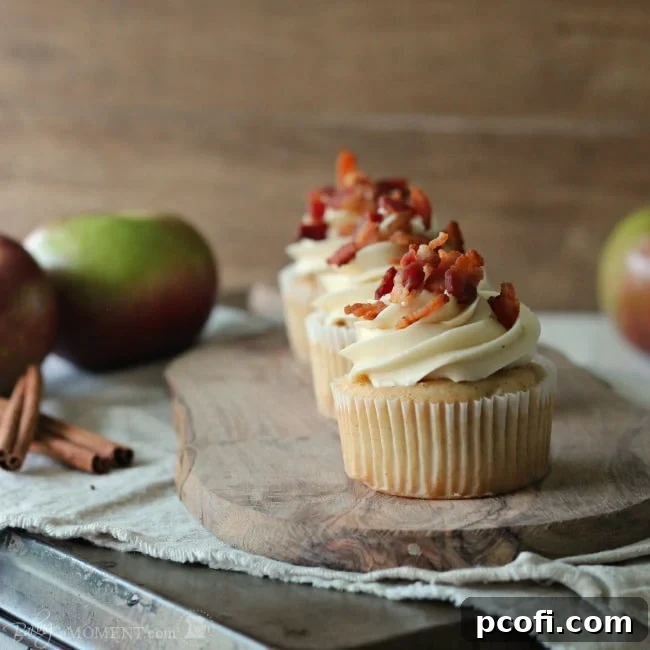 Delicious Apple Cinnamon Pancake Cupcakes, topped with a luscious maple buttercream and a sprinkle of crisp bacon, combining breakfast and dessert flavors.