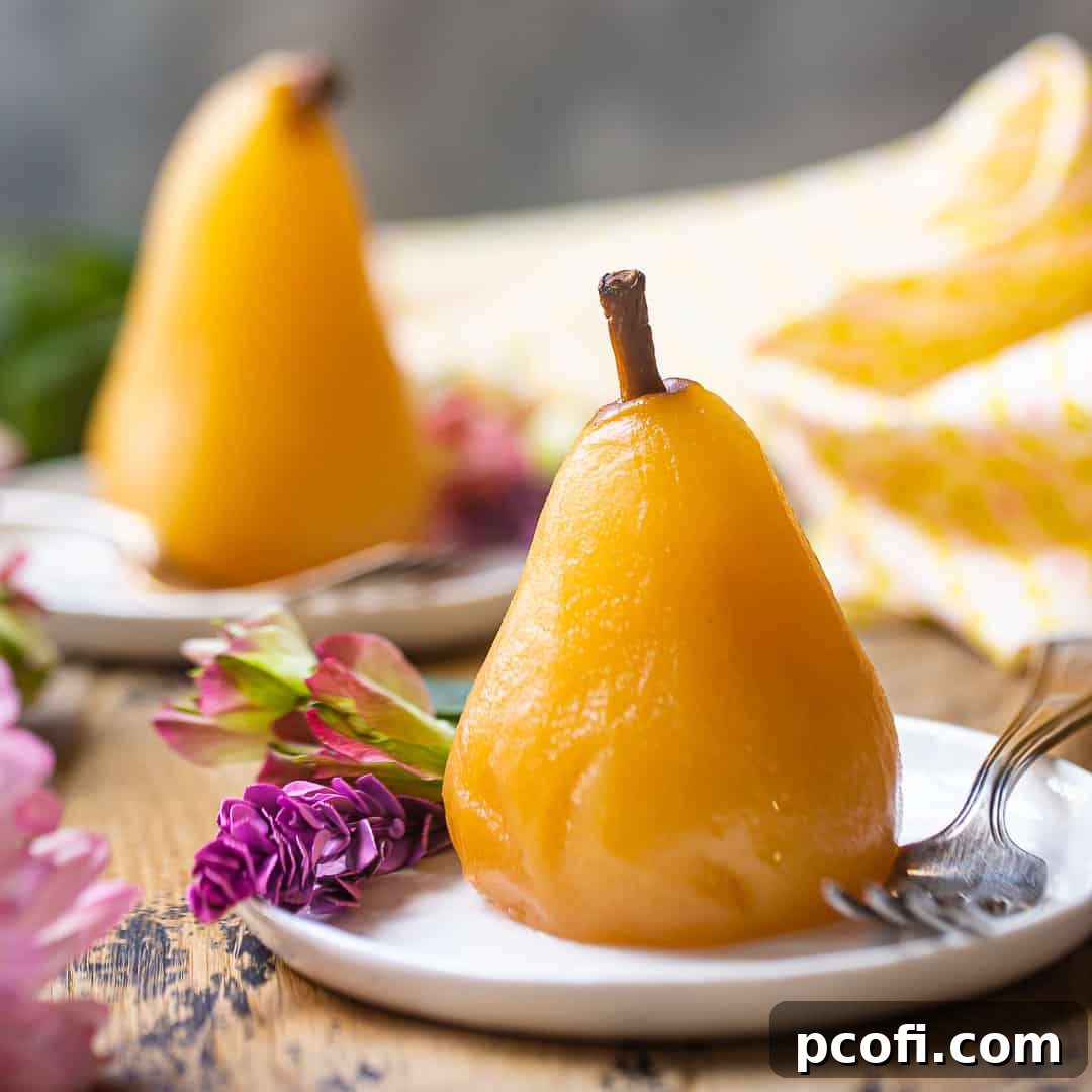 Poached pears served on small ceramic plates with pink flowers, an elegant dessert presentation.