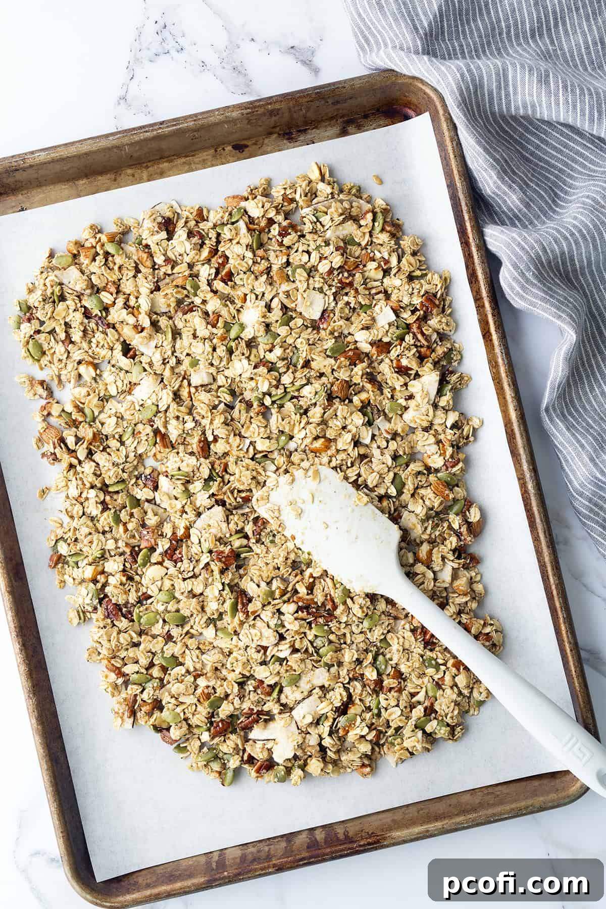 A spatula pressing granola