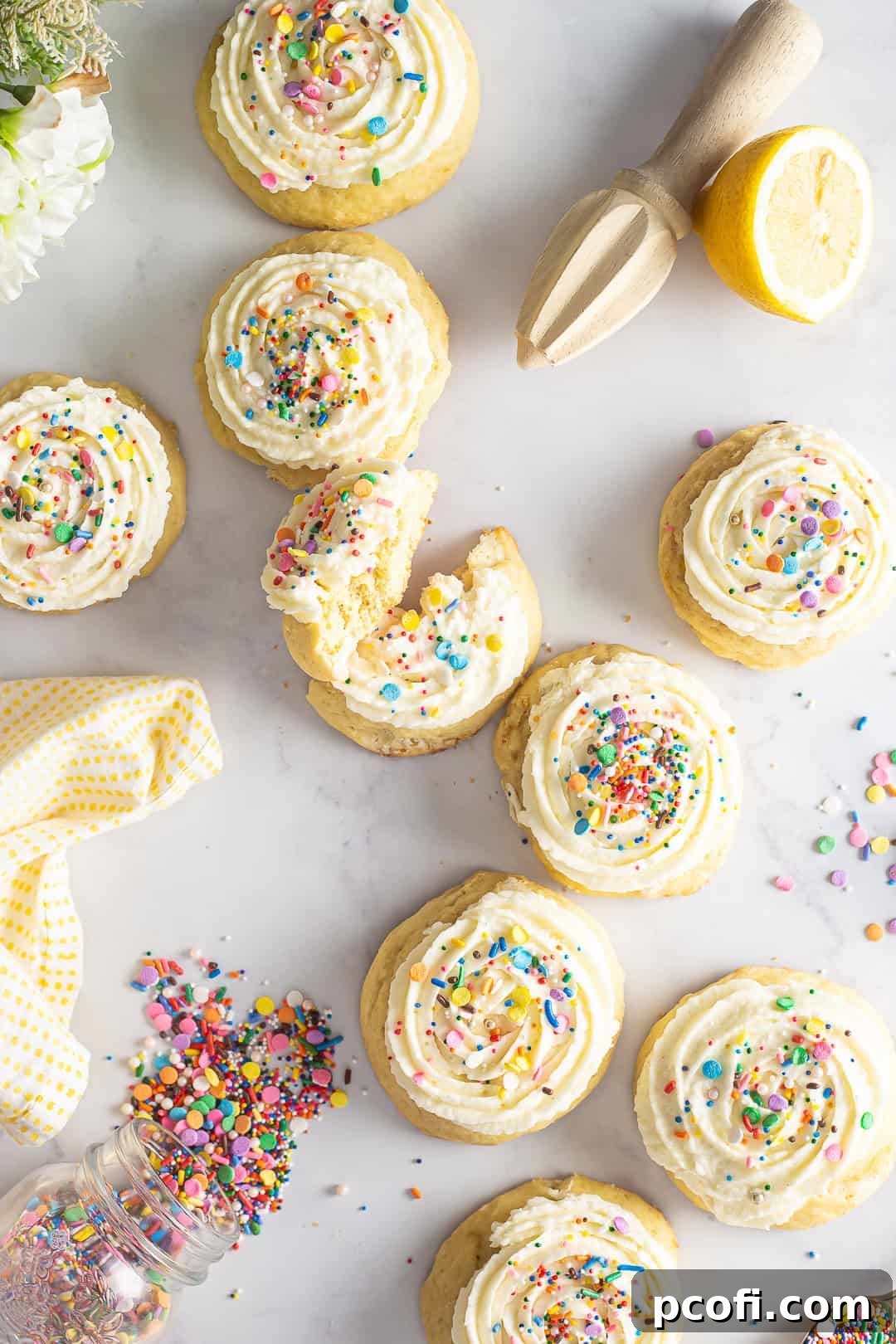 Ricotta cookies on a white marble background with sprinkles on top. 