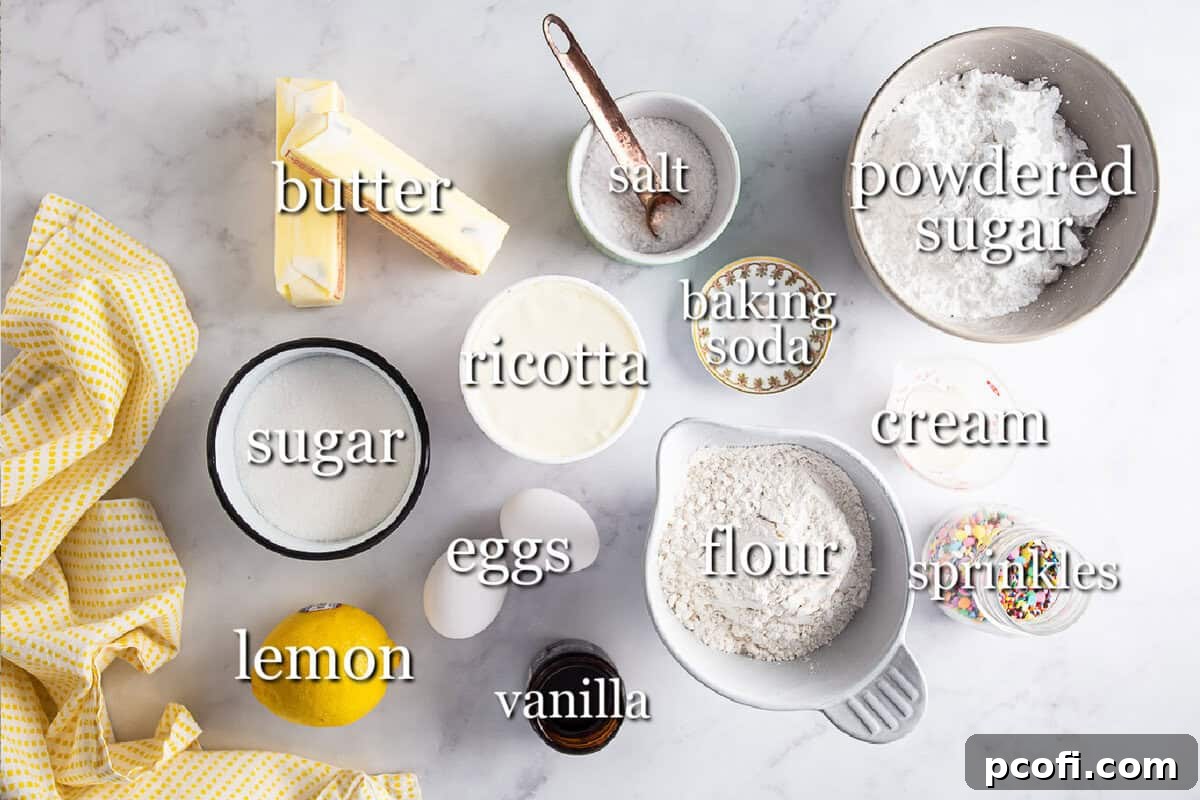 Ingredients for ricotta cookies in separate containers on a white marble background.