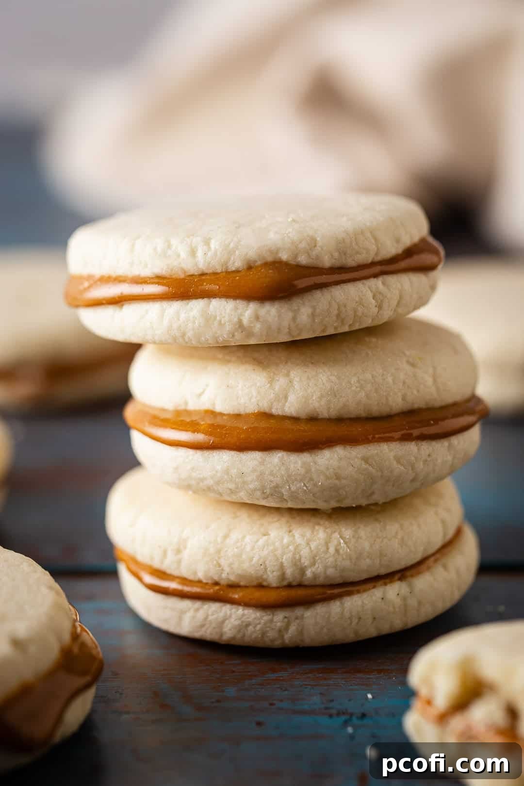 Alfajores cookies with dulce de leche sandwiched between them, stacked on top of each other. A delightful display of these classic South American treats.