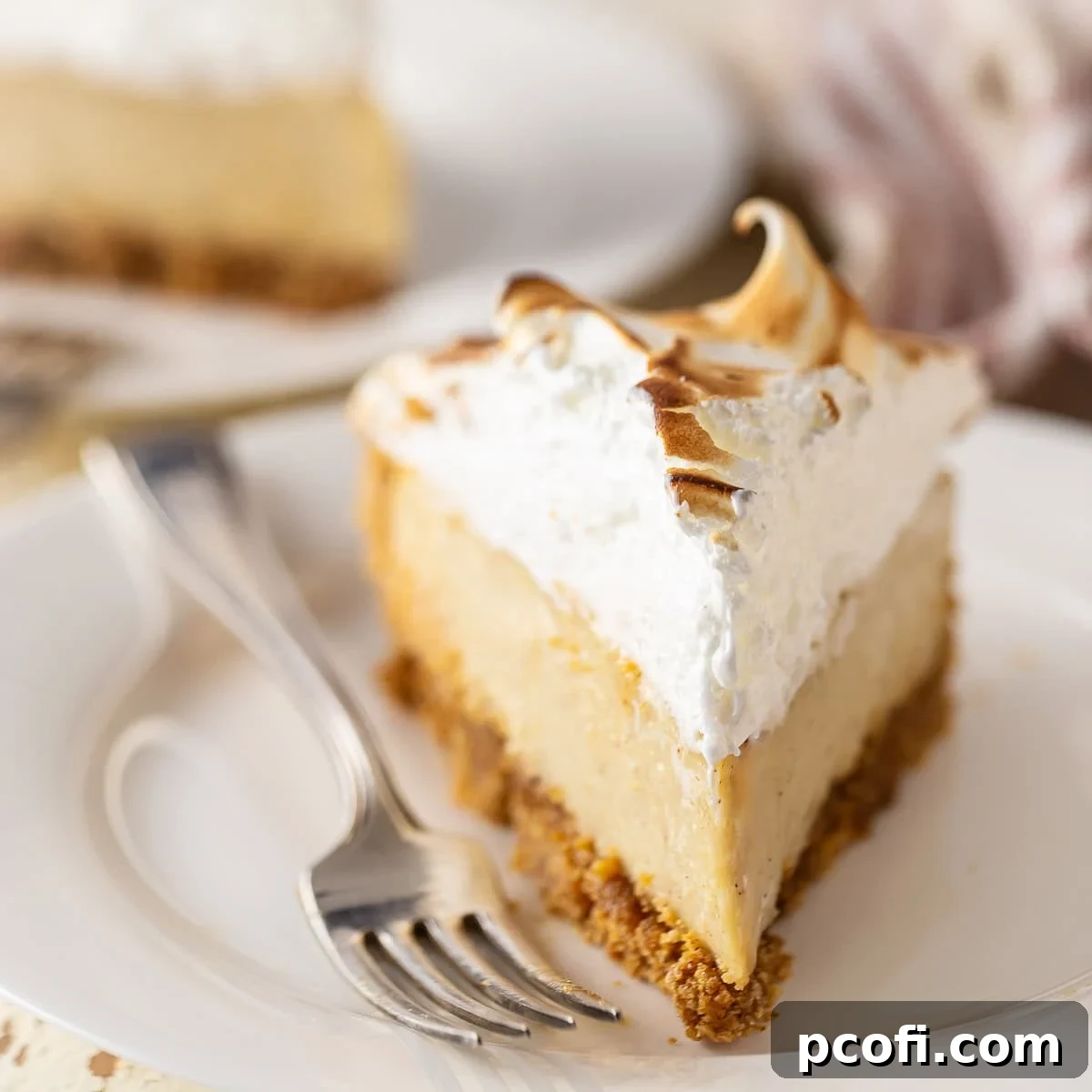 A slice of Eggnog Pie with a toasted meringue topping, served on a festive plate.