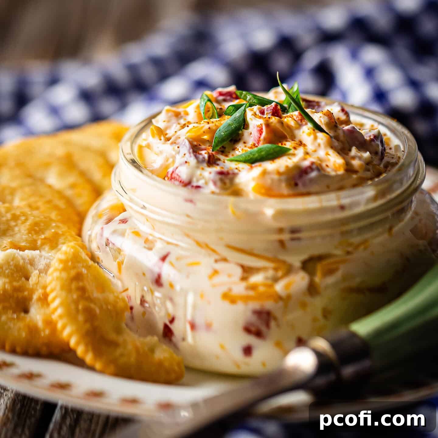 Creamy pimento cheese served in a rustic canning jar with buttery crackers for dipping.