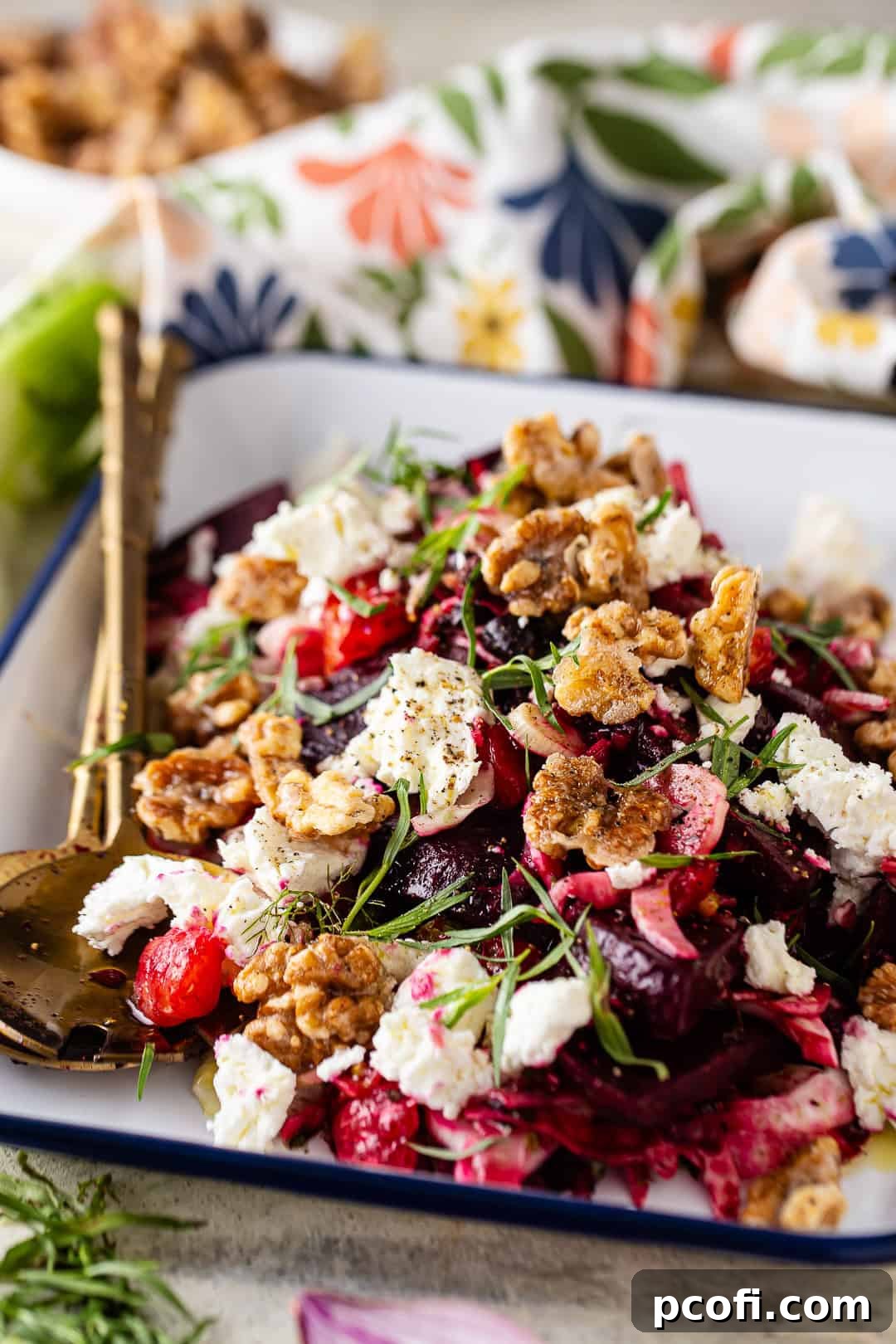 Beet salad on a serving platter with candied walnuts and goat cheese on top, ready to be enjoyed.