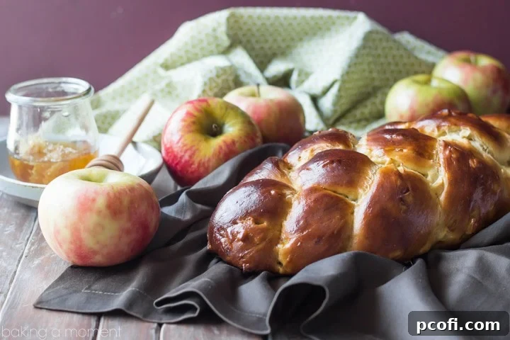 Four delicious Honey Apple Challah rolls or braids, beautifully arranged.