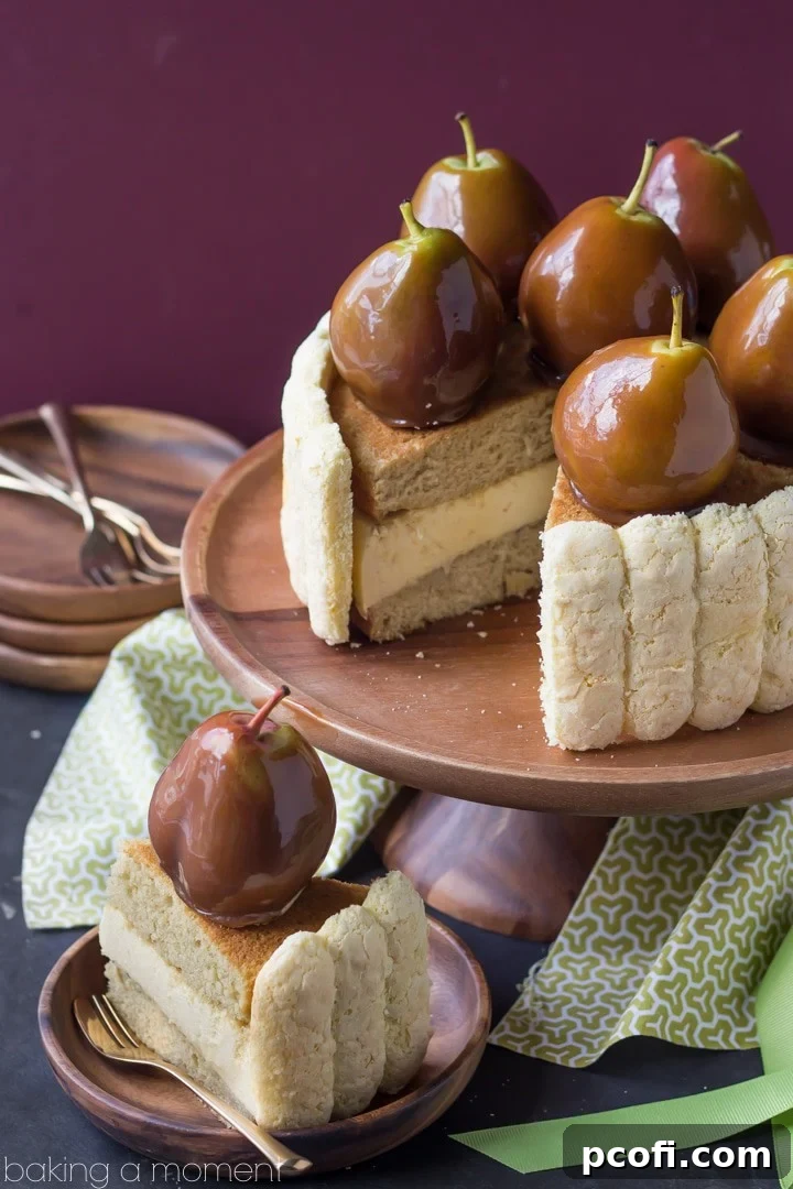 A slice of Caramel Pear Charlotte revealing the intricate layers of vanilla cake, pear mousse, and ladyfingers, topped with a caramel-dipped pear.