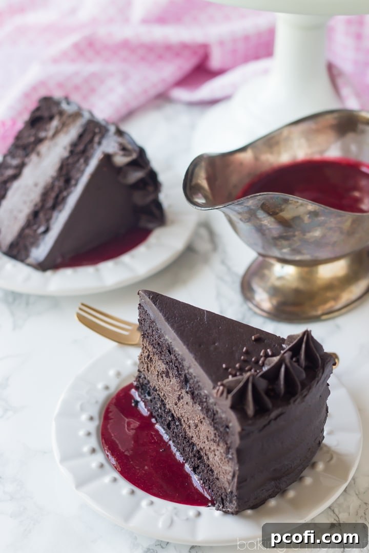 Brooklyn Blackout Cheesecake Cake with raspberry sauce, presented on a serving plate.