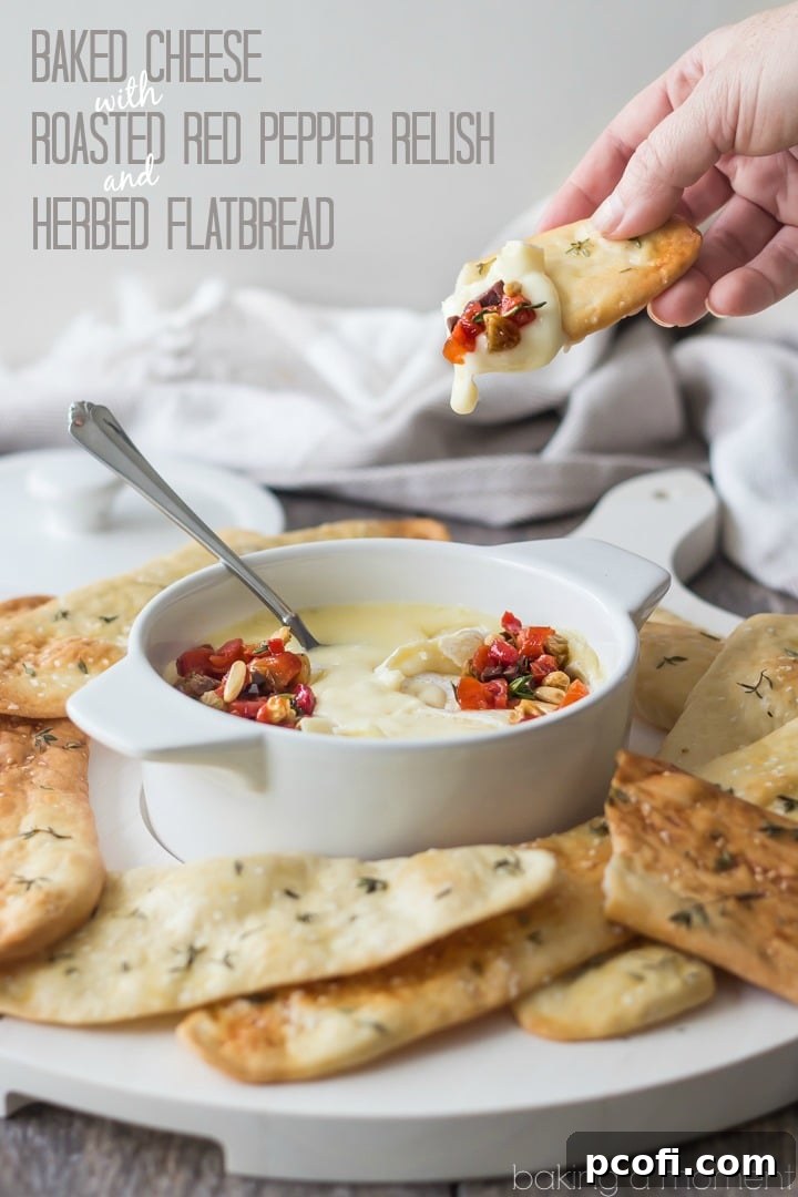 Delicious baked Robiola cheese with roasted red pepper relish, garnished with fresh herbs