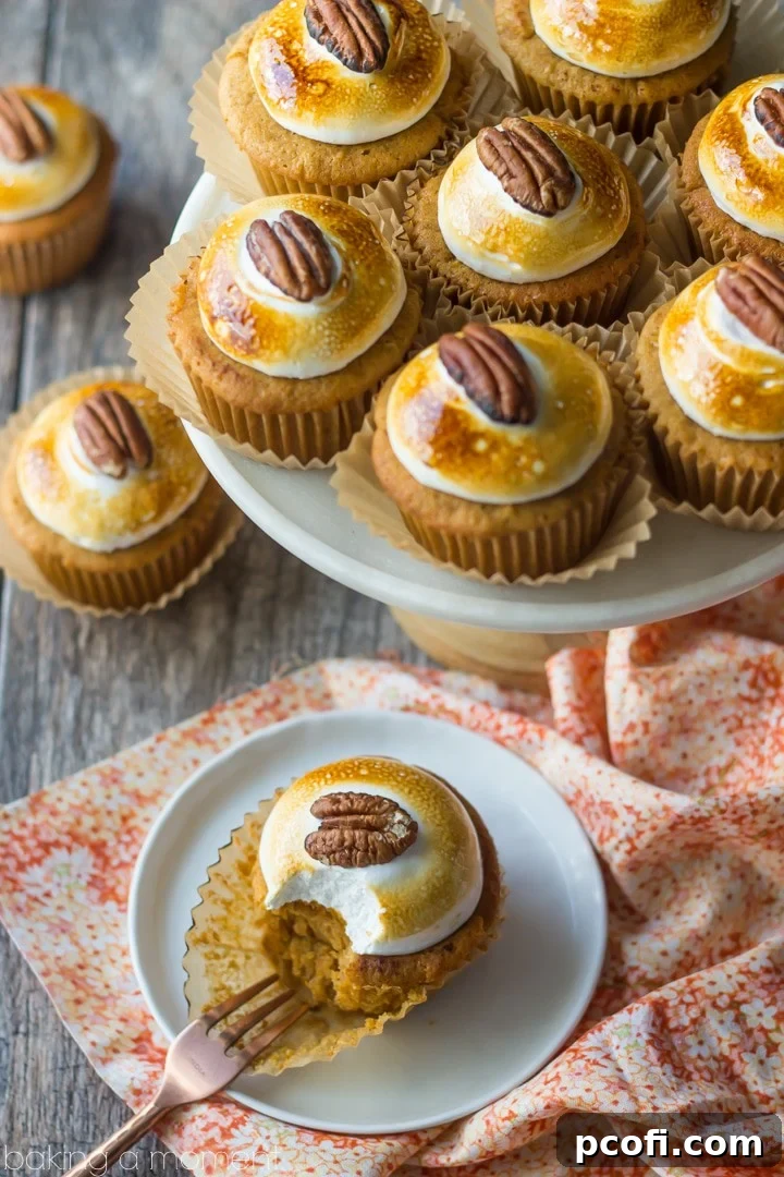 Finished Sweet Potato Souffle Cupcakes, arranged on a cooling rack, showcasing the toasted marshmallow and pecan garnish.