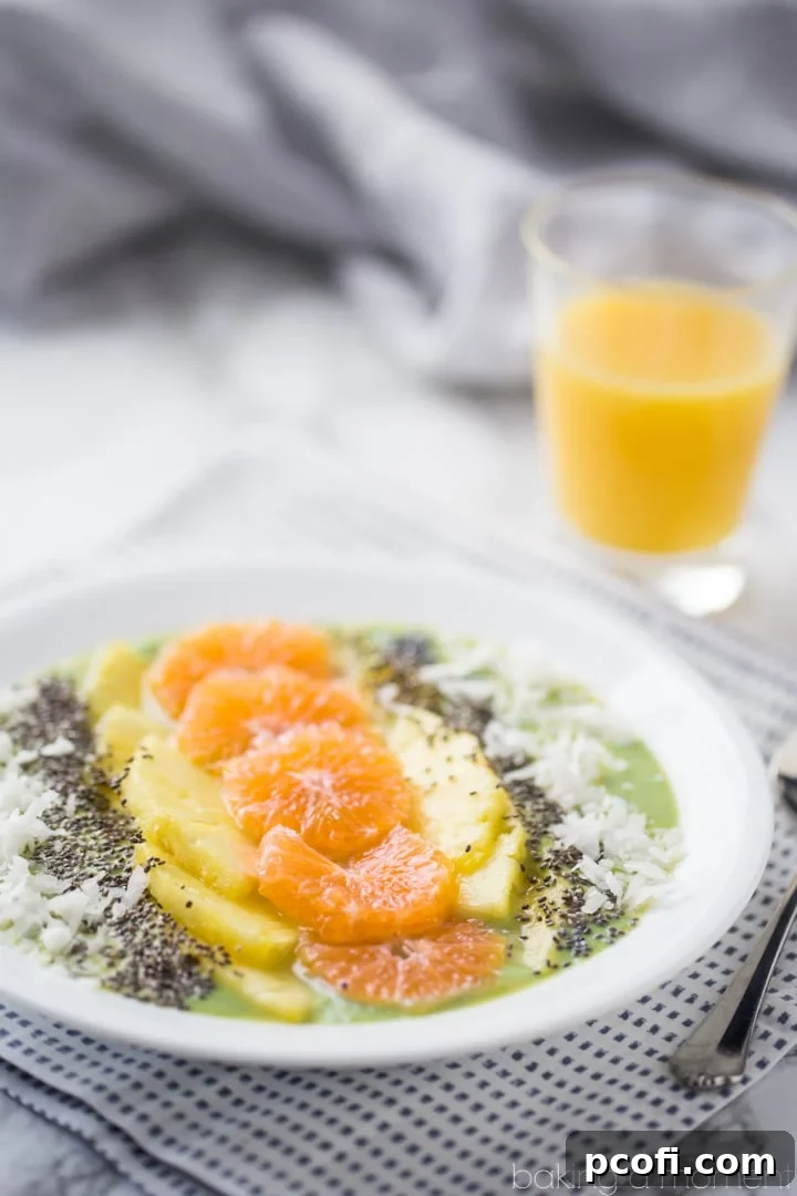 Overhead shot of a meticulously arranged tropical green smoothie bowl ready to be enjoyed.