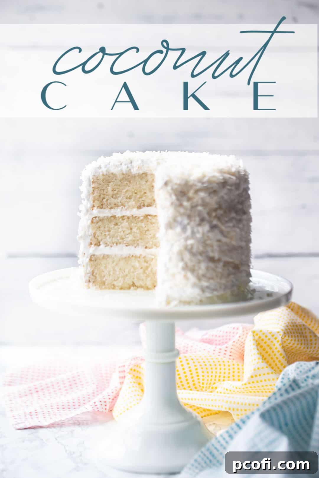Triple layer coconut cake recipe, baked and served on a white pedestal with a text overlay above reading "Coconut Cake." This image beautifully displays the cake