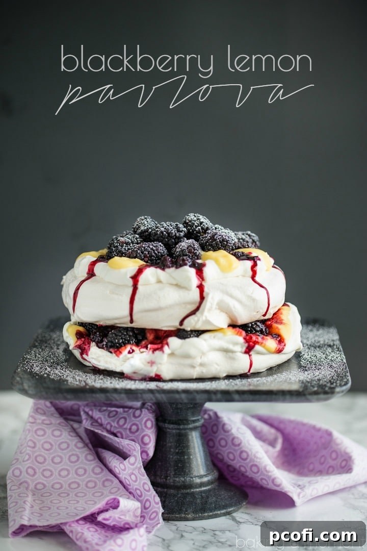 Close-up of a magnificent Blackberry Lemon Pavlova, showcasing its elegant layers and the enticing contrast between dark, juicy blackberries and bright, creamy lemon curd. This simple-to-make, gluten-free dessert is visually stunning and incredibly flavorful.