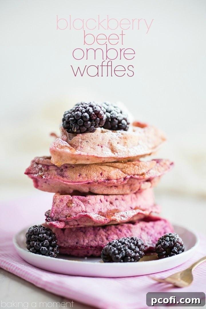 Close-up of vibrant pink ombre waffles topped with fresh blackberries and whipped cream.