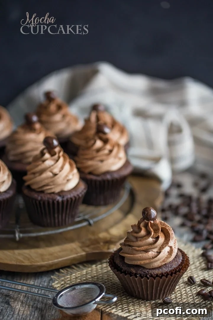 Close-up of a mocha cupcake with creamy espresso frosting and a chocolate-covered espresso bean.