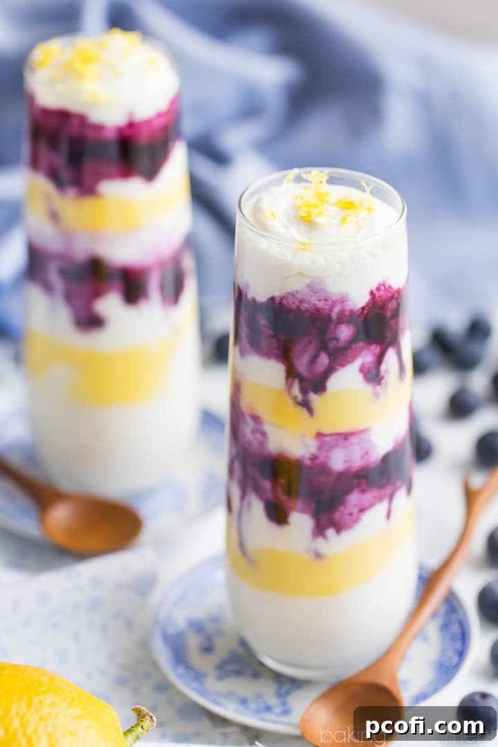Four lemon blueberry parfaits in stemless champagne flutes, ready for serving.