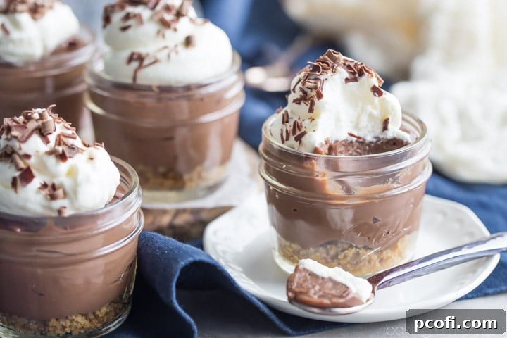 Chocolate Pudding Pie Jars ready to be served, topped with whipped cream and chocolate shavings.